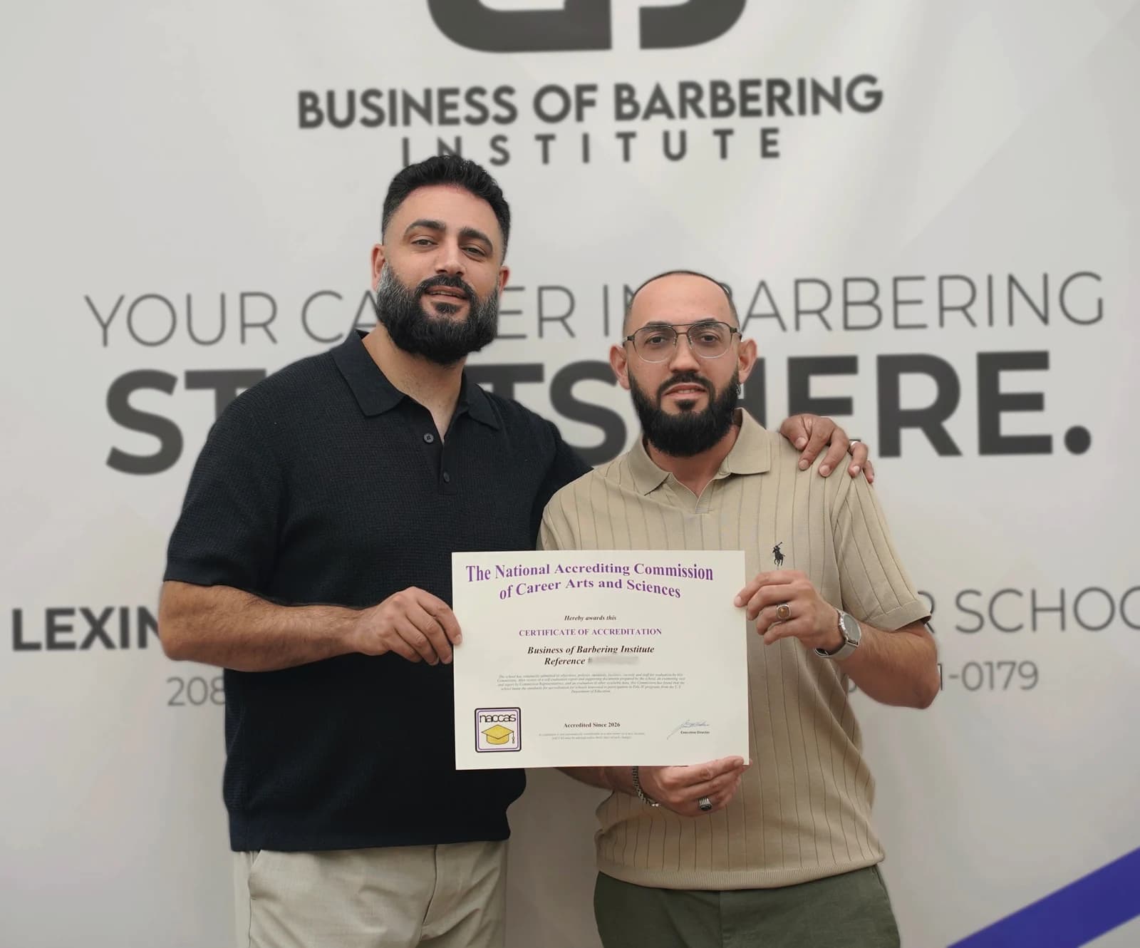 Two people holding the Business of Barbering Institute NACCAS certificate, marked Accredited Since 2026.